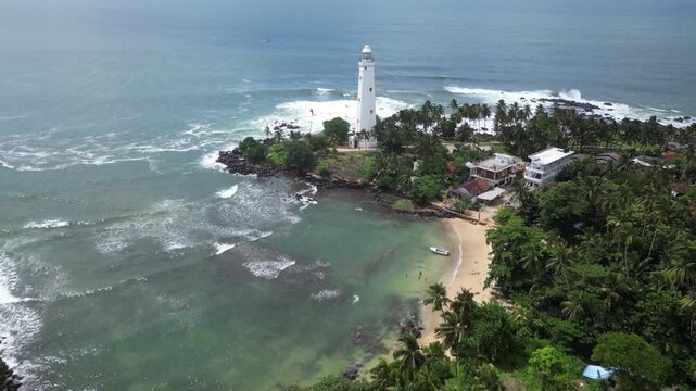 Aerial drone footage of a island lighthouse, showcasing its serene surroundings and the natural beauty of the ocean landscape