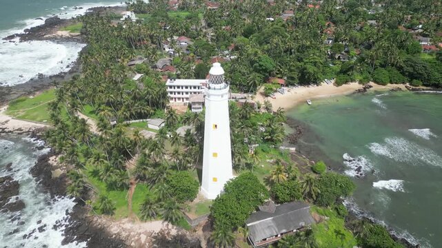 Aerial reveal shot of a lighthouse, capturing its ascent from the surrounding landscape to the iconic beacon above