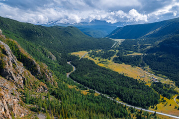 Aerial top view road in forest with car motion. Winding highway through green trees Altai. Concept ecosystem ecology healthy environment, travel trip