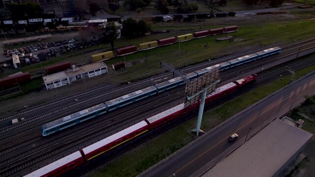 Cruce de Trenes al atardecer. Tren rojo y tren azul. Retiro, Buenos Aires, Argentina. Hora m&aacute;gica. Vista de Dron. Viaje en Tren. Footage de Tren. Footage de Viaje.