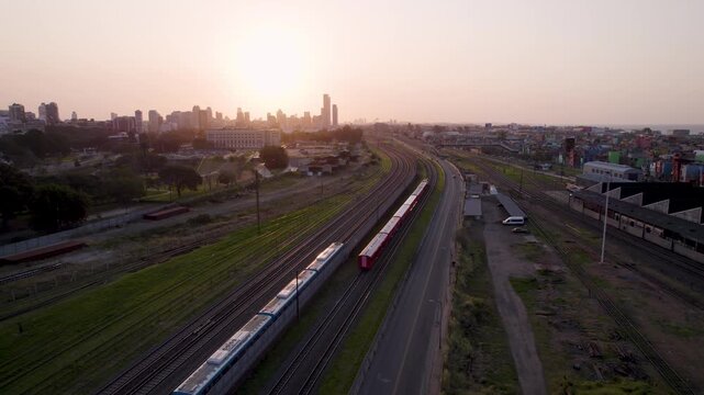 Cruce de Trenes al atardecer. Tren rojo y tren azul. Retiro, Buenos Aires, Argentina. Hora m&aacute;gica. Vista de Dron. Viaje en Tren. Footage de Tren. Footage de Viaje.