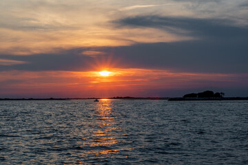 Fiery Sunset on the Sea with Distant Boat, View from Grado Lighthouse, Italy: Red Orange Colors in the Sky.