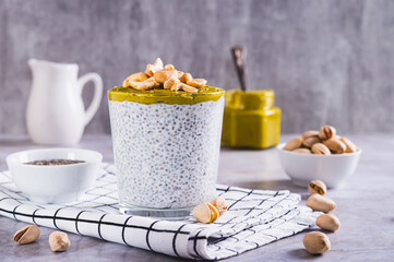 Organic chia pudding with pistachio butter and cashews in a glass on the table