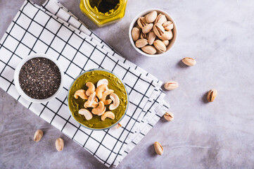 Organic chia pudding with pistachio butter and cashews in a glass on the table top view