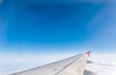 Obraz premium View from the airplane window at a beautiful cloudy sky and the airplane wing