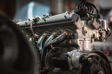 Newly restored engine for a classic car in a background stored in a vintage car restauration garage.