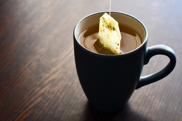 Putting a tea bag in hot water into a tea cup.