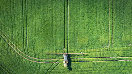 Tractor sprays fertilizer and water on a green fields of East Sussex, UK