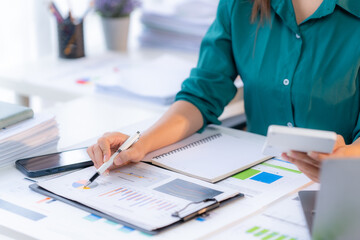 Financial Focus: Professional woman meticulously analyzes charts and crunches numbers with a...