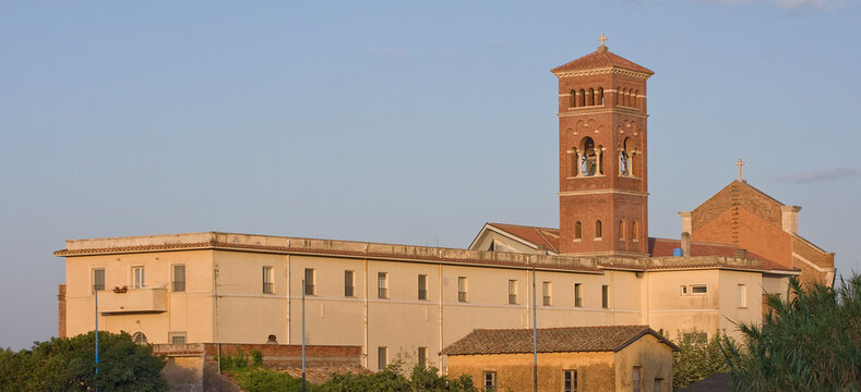 Historic Romanesque Catholic Church with Medieval Stone Bell Tower and Bell in a European Italian Town Under a Clear Blue Sky Anzio Nettuno Italy