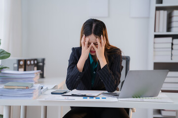 Overwhelmed and Exhausted: A portrait of a stressed businesswoman in a modern office setting, captured in a moment of emotional strain, her hands clutching her face, symbolizing the burdens of a deman