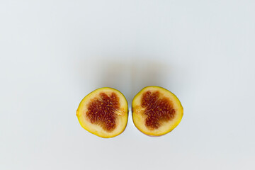 Yellow figs on a white background. Whole and halved figs