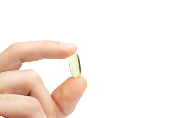 Male hand holding omega 3 soft gel capsule isolated on white background