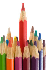 A cut above the rest A sharp row of colorful wooden art pencils and drawing crayons in a rainbow of red, green, blue, and yellow isolated on a white background for school education