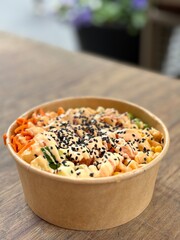 Poke bowl on wooden table with shallow background
