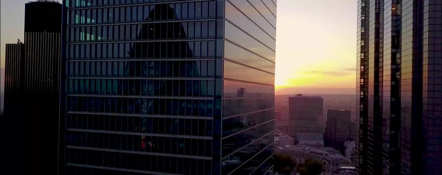 
As the sun begins to set over London, the city's iconic skyline is bathed in a warm, golden glow. From a drone's aerial perspective, the skyscrapers rise majestically, their glass facades reflecting 
