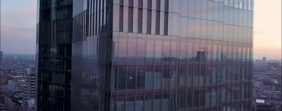 
As the sun begins to set over London, the city's iconic skyline is bathed in a warm, golden glow. From a drone's aerial perspective, the skyscrapers rise majestically, their glass facades reflecting 