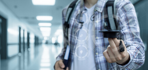 A student holds an academic cap on his finger.