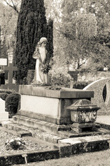 Stone crosses and tombstones in a cemetery. Black and white toned