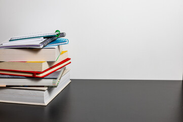 Stack of colourful books on a home desk. Concept of school preparation.