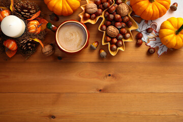 Autumn holiday, Thanksgiving background. Flat lay composition with pumpkins, leaf shaped plate with nuts, acorns, coffee cup, decorative candle with pine cones on wooden table. Top view, copy space.