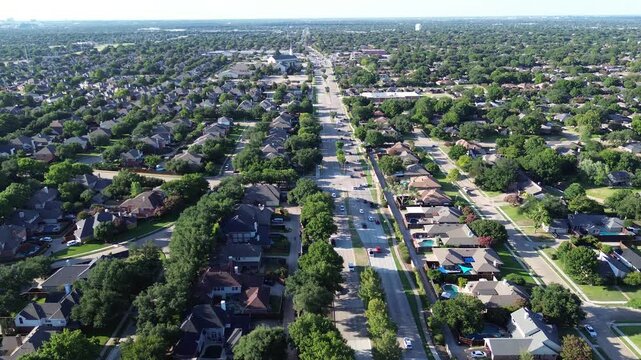 Busy traffic on Coit Rd toward W Parker Rd in Plano, Texas, upscale two-story suburban houses swimming pools, mature trees in Wentworth Estates, Preston Ridge, River Bend neighborhood, flyover