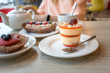 A plate of dessert with a raspberry on top sits on a table