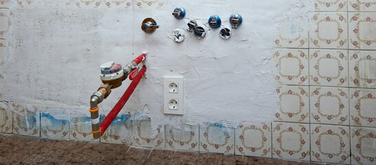 Water stopcocks, drains and hot water meter in a kitchen under renovation