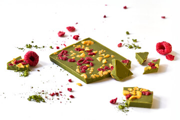 Matcha green tea chocolate with raspberries and dried passion fruit isolated on a white background   