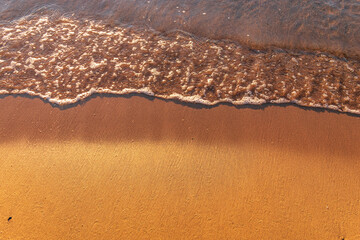 Soft wave of the sea on the sandy beach.