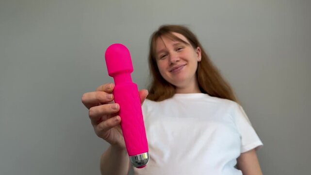 Happy young woman with sex toy for adults, female with vibrator 
