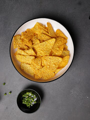 Savory salted corn chips on a plate with a plain background
