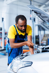 Engineer expertly examines car ignition system using advanced mechanical tools, ensuring optimal...