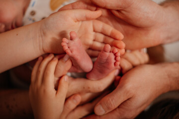 Tender moment of a newborn's tiny feet being gently held by loving hands, symbolizing care and family.