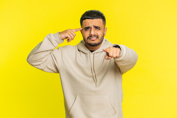 You are crazy, out of mind. Confused Indian Hindu man pointing at camera and showing stupid...