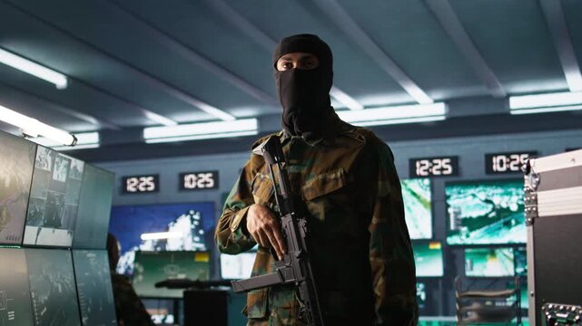 Terrorist occupying enemy base of operations, conducting guerilla warfare. Rebel forces hijacker with firearm in hidden war room starting offensive against opponents, camera B