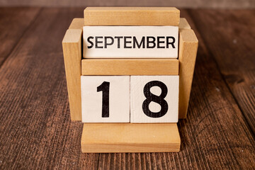 Close up of a wooden perpetual calendar showing the 18th of September.