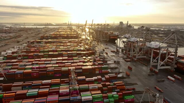 Rotterdam, Netherlands, Drone shot of modern industrial port of Rotterdam with containers in sunrise. Sightseeing panorama over sunset. It is an import and export cargo port where is a par