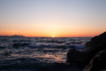 Obraz premium Looking east toward the Toronto Ontario Canada skyline at sunrise from Colonel Samuel Smith Park