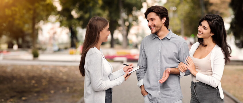 Exit Poll. Girl Interviewing Young Couple Of Voters Conducting Survey Standing Outdoor In City.