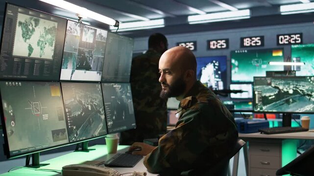 Man looking at screens in military HQ base housing operational missile defense system designed to intercept ballistic rockets. Special forces expert using tracking gear and radar systems, camera B
