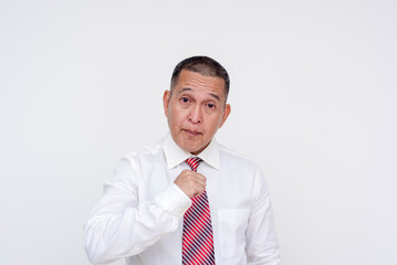 A middle aged asian manager reminding a subordinate that he is the boss. Speaking with an arrogant tone and pointing both hands to himself. Isolated on a white background.