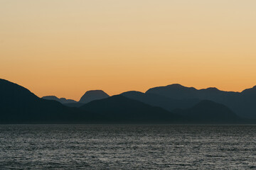 Naklejka premium Sunset views from ferry along British Columbia coastline along the Inside Passage in summer