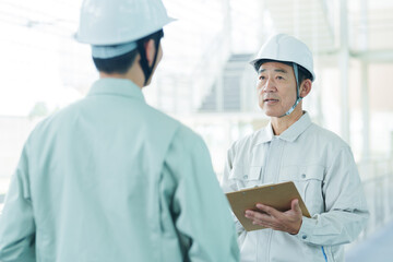 現場で打ち合わせをする作業員