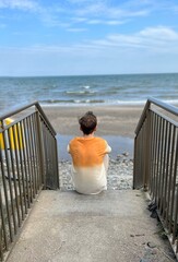Man in t shirt and pants standing on dock and looking on sea horizon