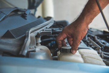Close up Mechanic man hands repairing car auto repair shop uses jack change tyre. Man hands fixing Shock absorber machinery vehicle mechanical service. Vehicle Car overhaul maintenance engineer