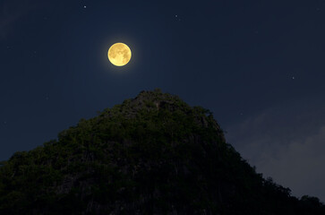 Fototapeta premium Bright full moon over mountaintop in the night