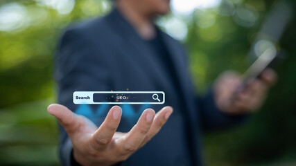 A man is holding a cell phone with a search bar on it