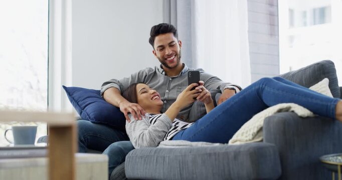 Couple, cellphone and social media on living room sofa, memes and technology. Bonding together, happy and dating for relaxing, mobile app and texting for communication, streaming and connection