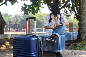 Fototapeta premium Selective Focus Of Blue Luggage Bag Against Blurred Tourist Man 